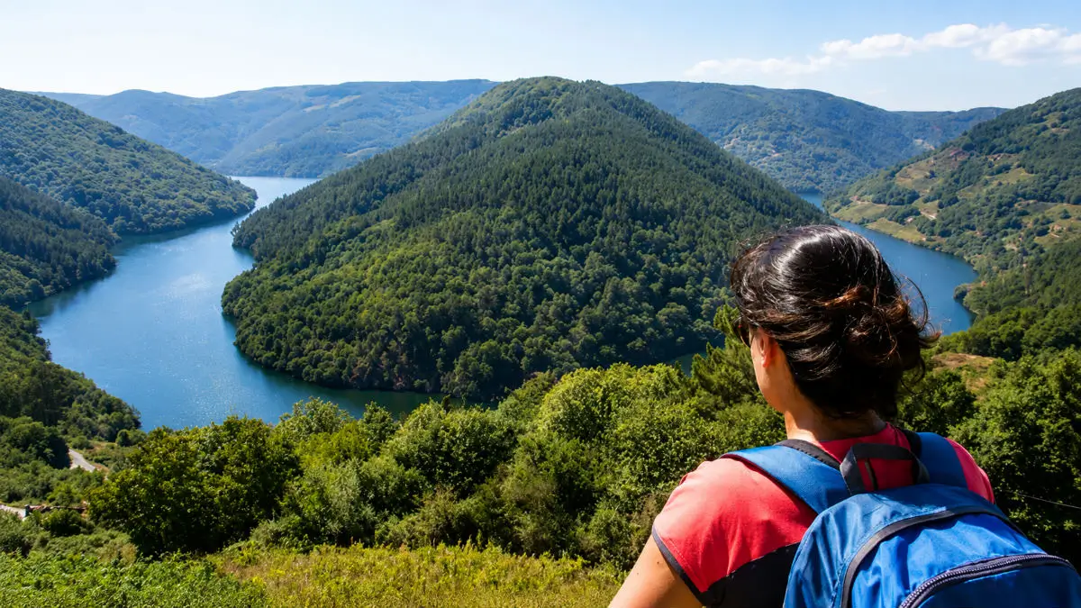 Peregrina contemplando el río Sil en la Ribeira Sacra durante el Camino de Invierno