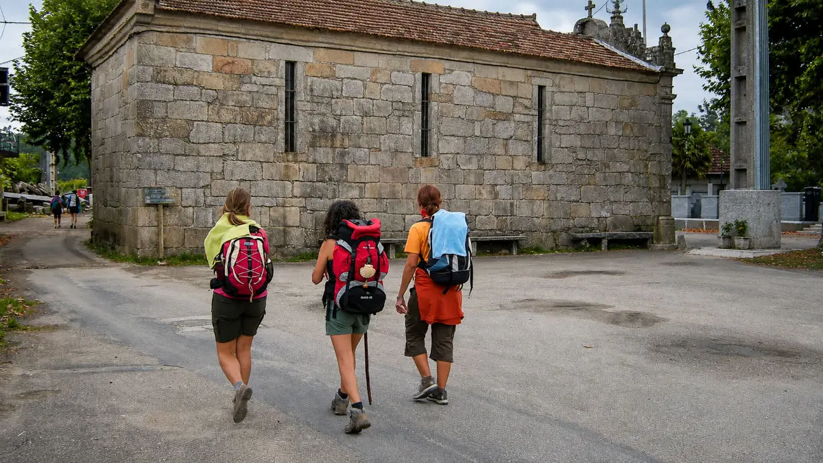 Peregrinos junto a la capilla de la Virgen del Camino en el Camino Portugués Central