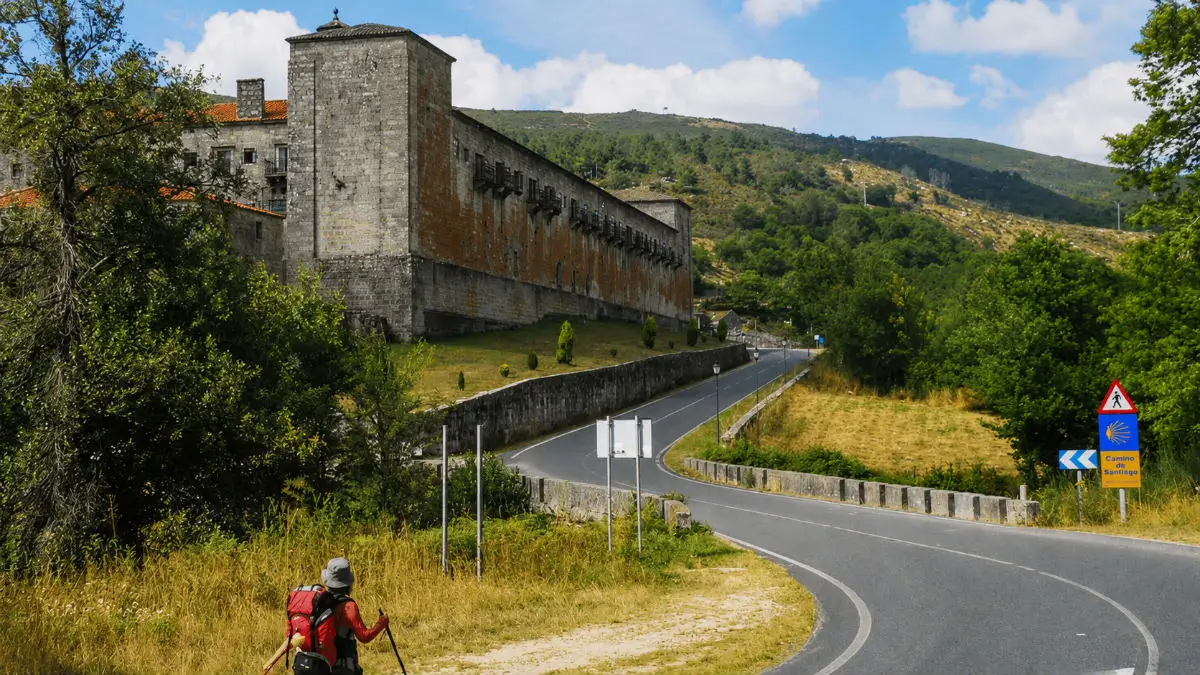 Peregrino caminando junto al Monasterio de Oseira en el Camino Sanabrés